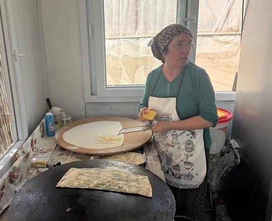 A chef cooking Gözleme, Turkish Pancakes, on a large circular hot plate